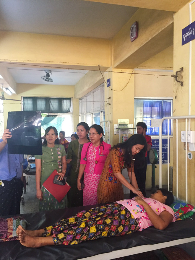 Dr Kyi Lai Ye Lynn examines a patient during a ward round with Professor Mar Mar Kyi, Dr Thin Zar Cho Oo and Dr Nan Phyu Sin Toe Myint.